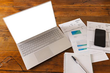 Documents, notebook, smartphone and laptop with copy space on table