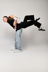 A man gracefully carries a woman on his back, showcasing strength, trust, and the bond between a...