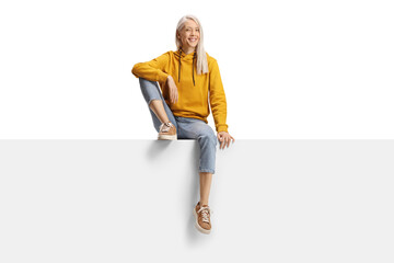 Blond female sitting on a blank panel