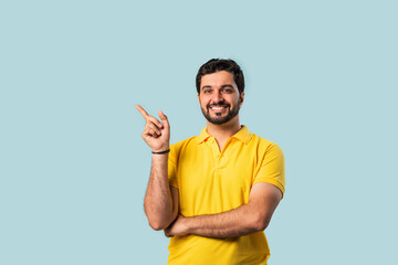 Happy Indian Asian Bearded Man Pointing at Copy Space, Looking Shocked, Blue Background
