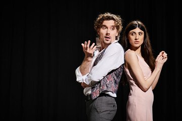 A man and woman perform on stage during theater rehearsals.