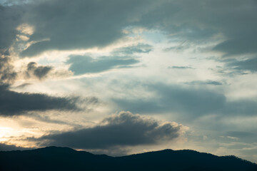 The sky is cloudy and the sun is setting. The clouds are low and the sky is darkening