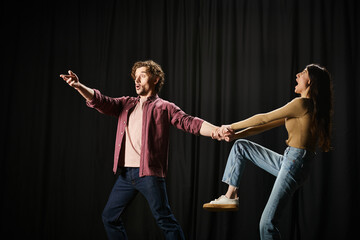 A man and woman stand elegantly during theater rehearsals.