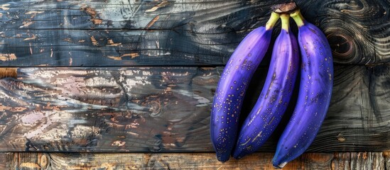 Top-down view of delicious purple bananas on a wooden surface with sufficient copy space for text.