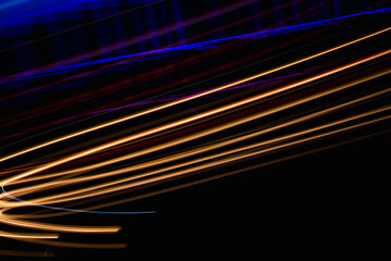 A black background with orange and blue lines. The lines are blurry and the colors are vibrant. The image has a dynamic and energetic feel to it