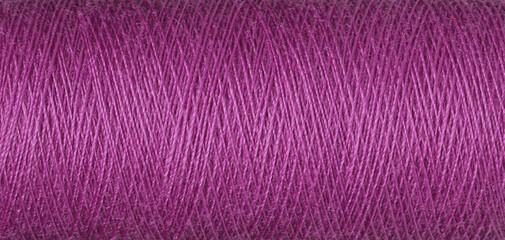 macro texture of a skein of pink sewing thread