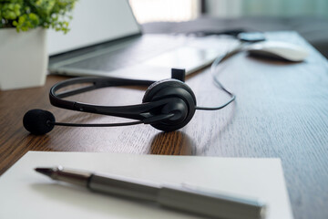 Headphones connected to a laptop for an online meeting are placed aside during a break.