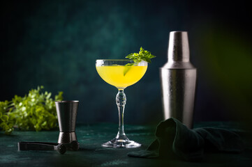 Tropical yellow lemon cocktail on green background