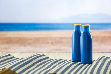 Beach accessories on summer beach mat on a tropical sandy beach. Seascape background. Copy space for montage products display.