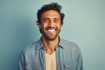 Fototapeta premium Portrait of a grinning man in his 30s sporting a versatile denim shirt isolated in pastel or soft colors background