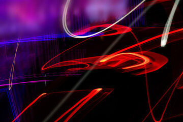 A blurry image of a car with red and purple streaks. The image is abstract and has a dreamy, surreal quality to it