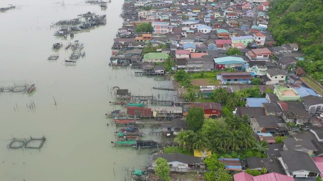 Aerial view of fishing trap net in canel with fisherman urban city village town houses, lake or river. Nature landscape fisheries and fishing tools at Pak Pha, Songkhla, Thailand. Aquaculture farming