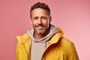 Obraz premium Portrait of a happy man in his 40s dressed in a water-resistant gilet in pastel or soft colors background