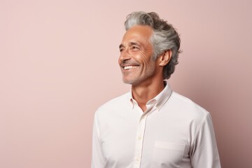 Obraz premium Portrait of a joyful man in his 50s wearing a simple cotton shirt isolated in pastel or soft colors background