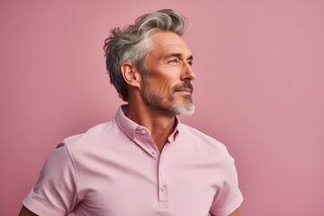 Obraz premium Portrait of a tender man in his 50s sporting a technical climbing shirt while standing against pastel or soft colors background