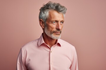Fototapeta premium Portrait of a tender man in his 50s sporting a technical climbing shirt isolated on pastel or soft colors background