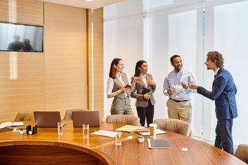 Multicultural business professionals in discussion around conference table.