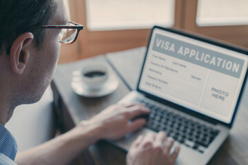 Online visa application, man filling form for immigration or tourism visa request for foreign...