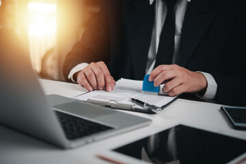 Businessman in suit stamping a document, approving contract. Professional corporate setup for legal agreements, official paperwork. Signature, authority process.