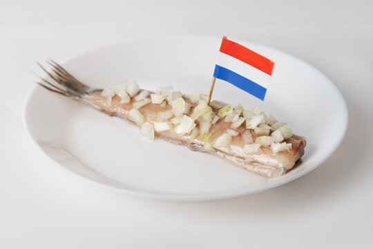 Dutch herring with onion on plate, Netherlands flag