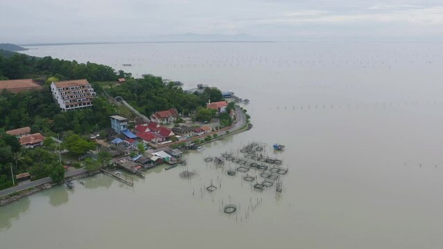 Aerial view of fishing trap net in canel with fisherman urban city village town houses, lake or river. Nature landscape fisheries and fishing tools at Pak Pha, Songkhla, Thailand. Aquaculture farming