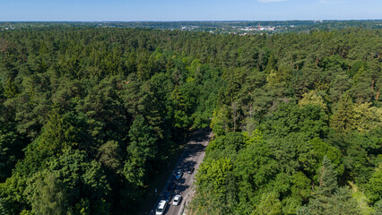 Obraz premium Drone photography of road, traffic, forest and houses during summer day