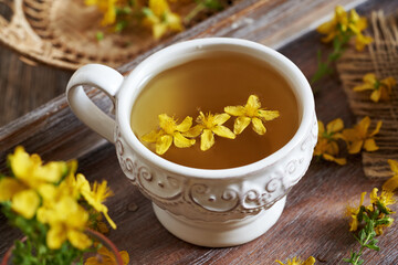 St. John's wort or Hypericum flower tea in a white ceramic vintage cup