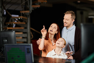 A man and a woman eagerly point up computer screen, engaged in a discussion or discovery together.