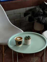 Plastic cup of latte art on the green table