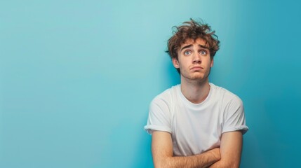 Obraz premium Portrait of an unhappy young man , blue color background, with copy space