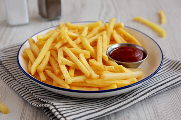 Homemade American French Fries with Ketchup on a Plate, side view. Close-up.