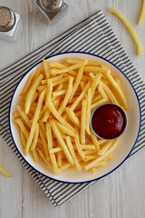 Homemade American French Fries with Ketchup on a Plate, top view.