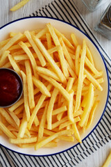 Homemade American French Fries with Ketchup on a Plate, top view. Close-up.