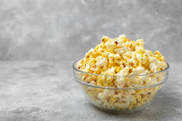 Bowl of salted popcorn on texture background.Cinema and entertainment concept. Movie night with popcorn. Delicious appetizer, snack. Place for text. Copy space. Banner