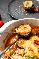 Italian dinner with homemade baked eggplant Parmigiana di melanzane, made with mozzarella, tomato.