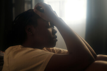 Side view of young desperate woman keeping her hands on head and eyes closed while suffering from...