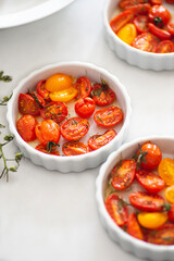 Baked multi-colored cherry tomatoes in small porcelain format, white background