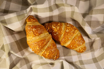 Homemade fresh croissant. Fragrant baking on a towel. Ecological concept. View from above