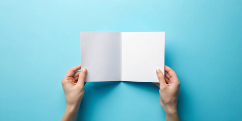 Hand holding blank brochure booklet or book mockup on blue background. Woman showing offset paper. Leaflet mock up holding hand. square Booklet template. A5 paper sheet display read first person