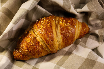 Homemade fresh croissant. Fragrant baking on a towel. Ecological concept. View from above