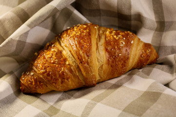 Homemade fresh croissant. Fragrant baking on a towel. Ecological concept. View from above