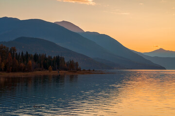 Obraz premium Majestic mountain range reflecting in calm lake at sunset