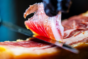 Chef cutting dry-cured spanish ham Jamon.