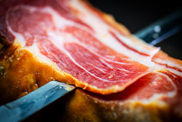 Chef cutting dry-cured spanish ham Jamon.