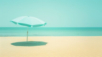 A lone beach umbrella sits on a sandy beach with a blue ocean behind it