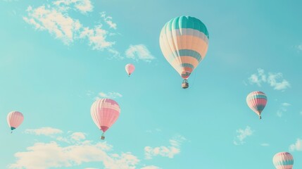 Naklejka premium Several hot air balloons, with pink and blue patterns, drift in a clear blue sky dotted with white clouds