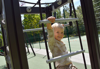 Obraz premium Happy little boy climbing in adventure activity park