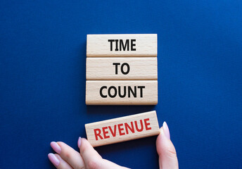 Time to count Revenue symbol. Wooden blocks with words Time to count Revenue. Beautiful deep blue background. Businessman hand. Business and Time to count Revenue concept. Copy space.