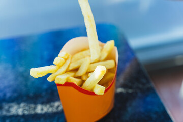 French fries in a paper container with one fry sticking out