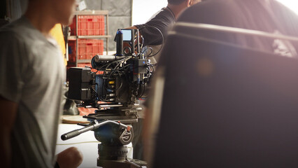 Film director and crew making commercial content advertising in studio. Filmmaker crew team with professional cinema equipment and video camera on the set. Technique of modern filming and advertising.